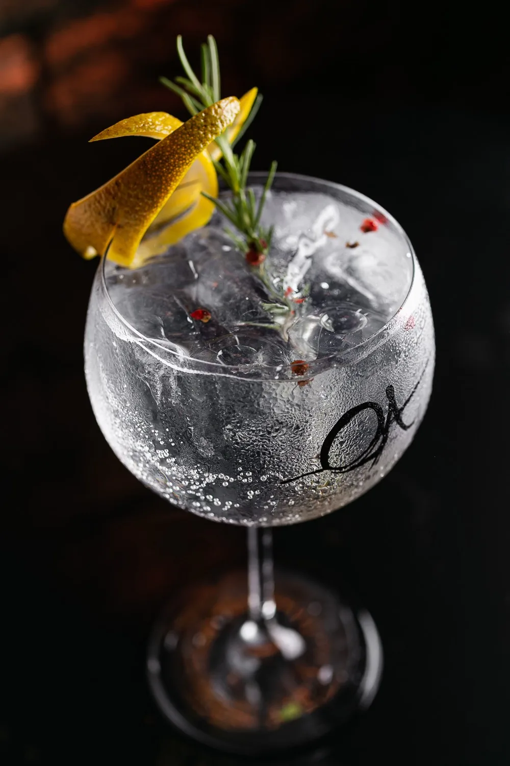 Gin tônica com alecrim e casca de limão na taça do Ópera Arte